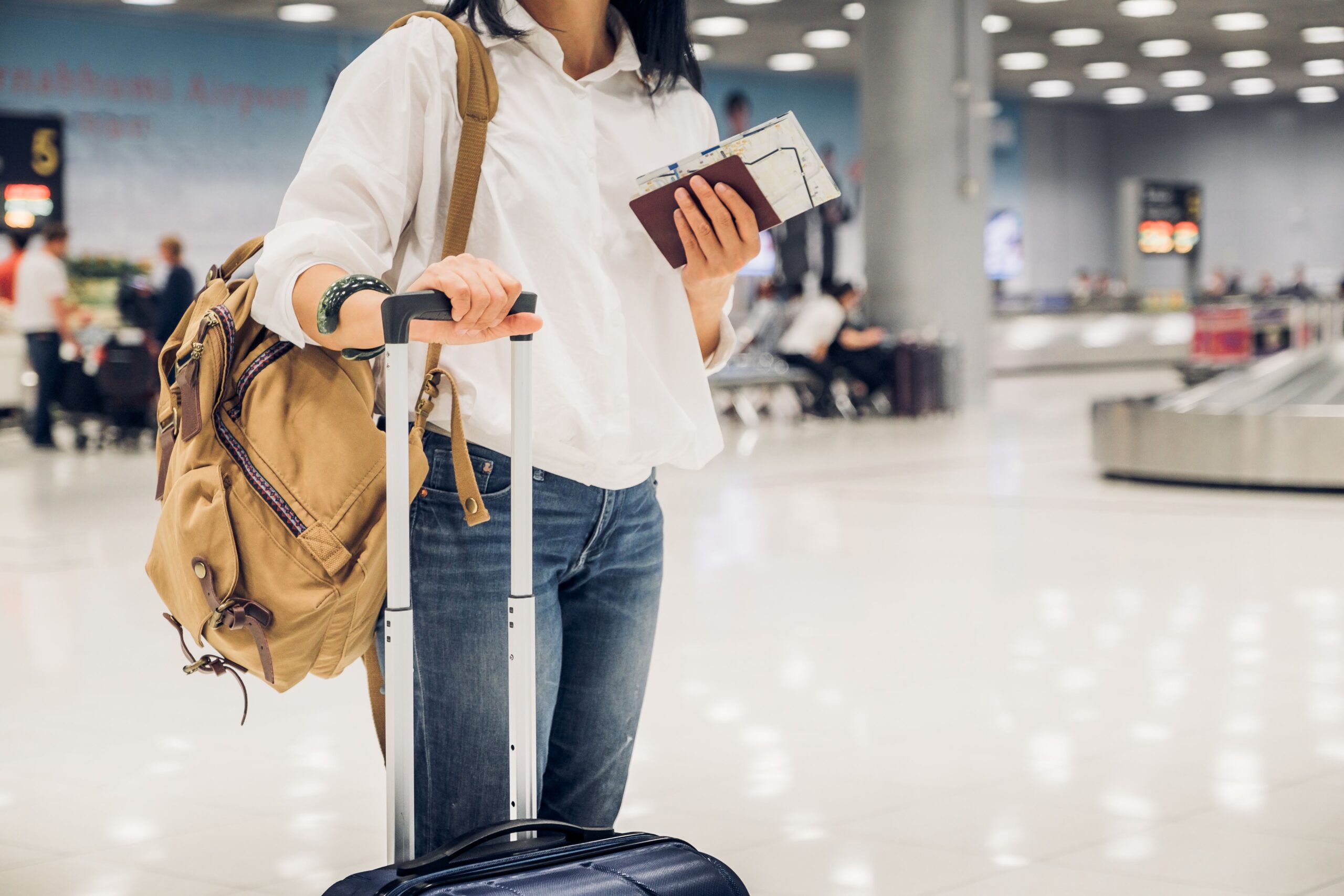 woman backpacker holding passport and map with suitcase standing